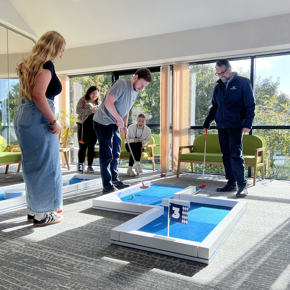 Team Building Mini Golf - Workplace Putt-Off Event Team building event with colleagues playing office crazy golf